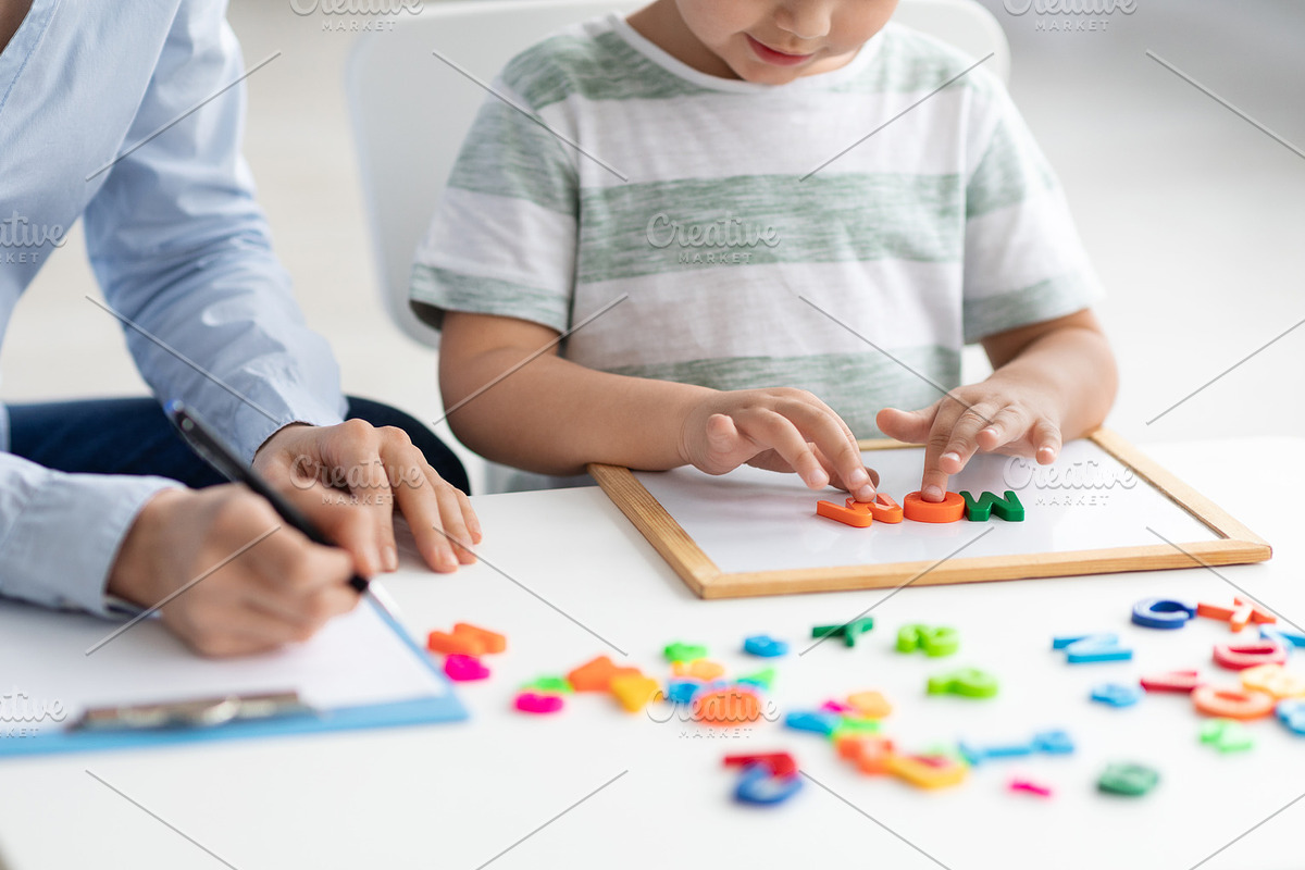 Cute little kid at speech therapist office. Close up of unrecognizable boy lear, a Photo by Prostock-Studio (Photo 2 of 2)
