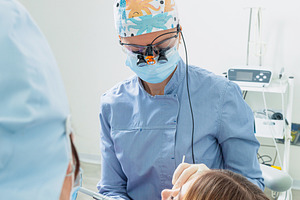 Dentist and assistant performing dental checkup on young woman, a Health & Medical Photo by Antonio Gravante Market