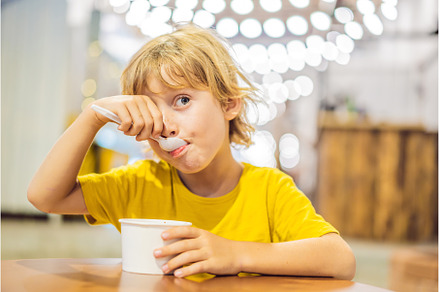 Boy eating ice cream in a cafe, a Person Photo by Elizaveta Galitskaya