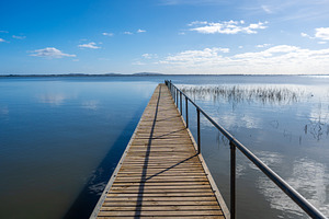 Wooden pier extending over Lake Colac, Victoria, Australia on a, an Architecture Photo by GoodGoods