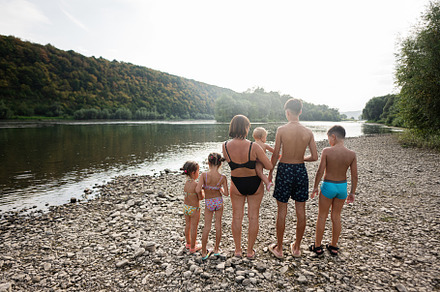 Family enjoying a day by the river pebble shore, a Person Photo by AS photostudio