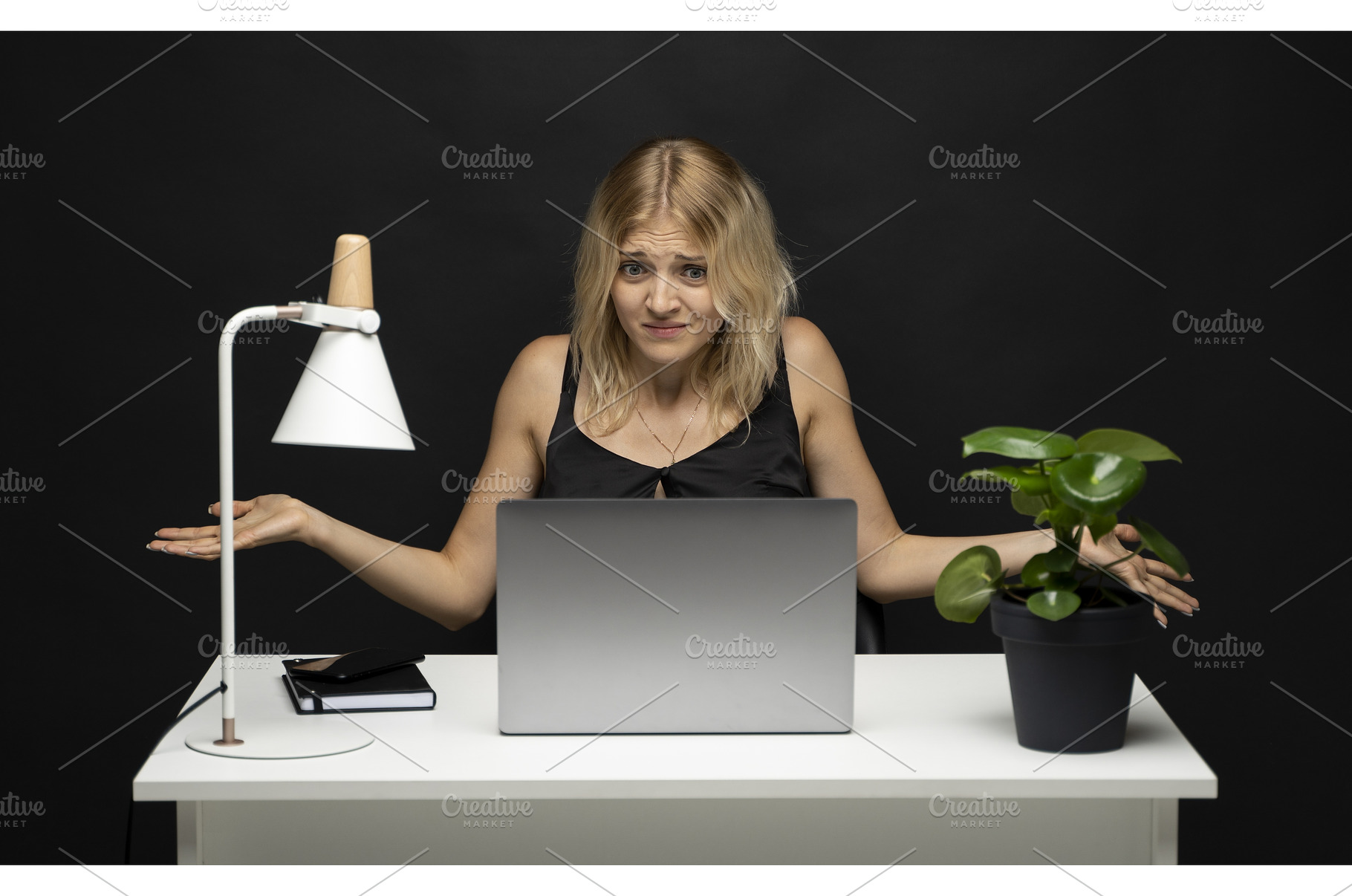 Confused young woman at desk, a Business Photo by volodymyrshtun13795