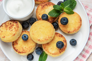 Syrniki cottage cheese pancakes served with blueberries and sour, a Food & Drink Photo by Olena Rudo