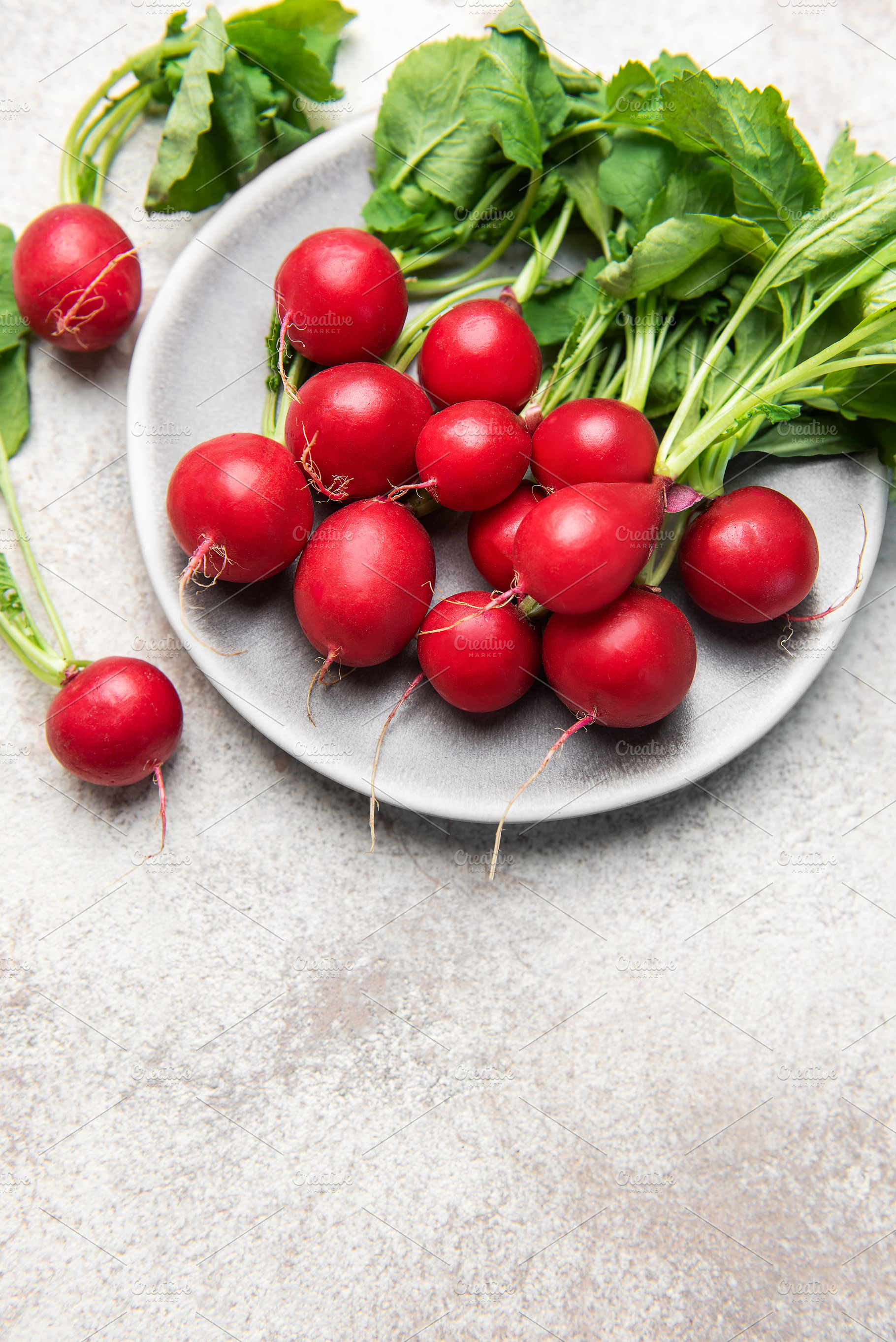 Fresh red radishes with green leaves on plate, a Food & Drink Photo by Olena Rudo
