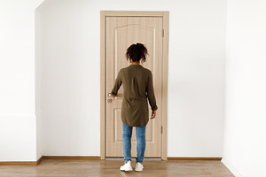 Back View Of Black Female Opening Apartment Door Standing Indoor, a Photo by Prostock-Studio