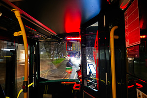 Night bus ride inside a Manchester bus with red interior lights and city street, a Photo by AS photostudio