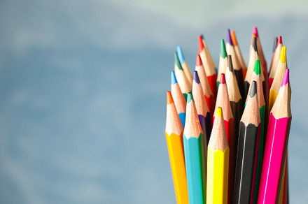 Multicolored pencils against light blue background, closeup, a School & Education Photo by AtlasStudio