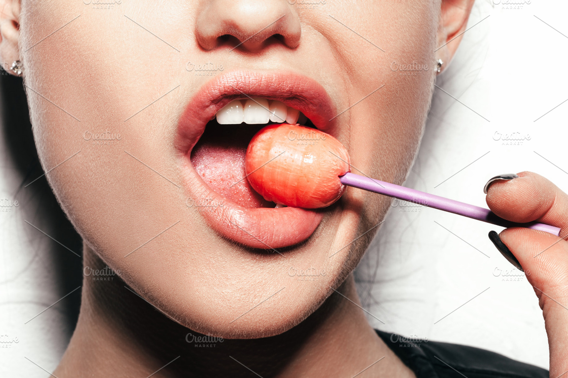 Woman licking  red shiny lollipop stock photo containing red and white, a Food & Drink Photo by Aliaksei Kaponia