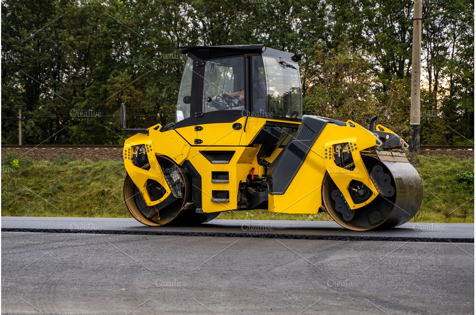 Yellow road roller compacting fresh, an Industrial Photo by volodymyrshtun13795