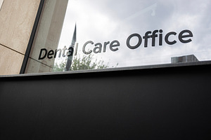 Exterior view of a dental care office building with reflective glass windows, a Photo by AS photostudio