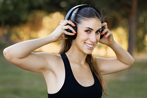 Young woman smiling with wireless he, a Sports & Recreation Photo by Perpis