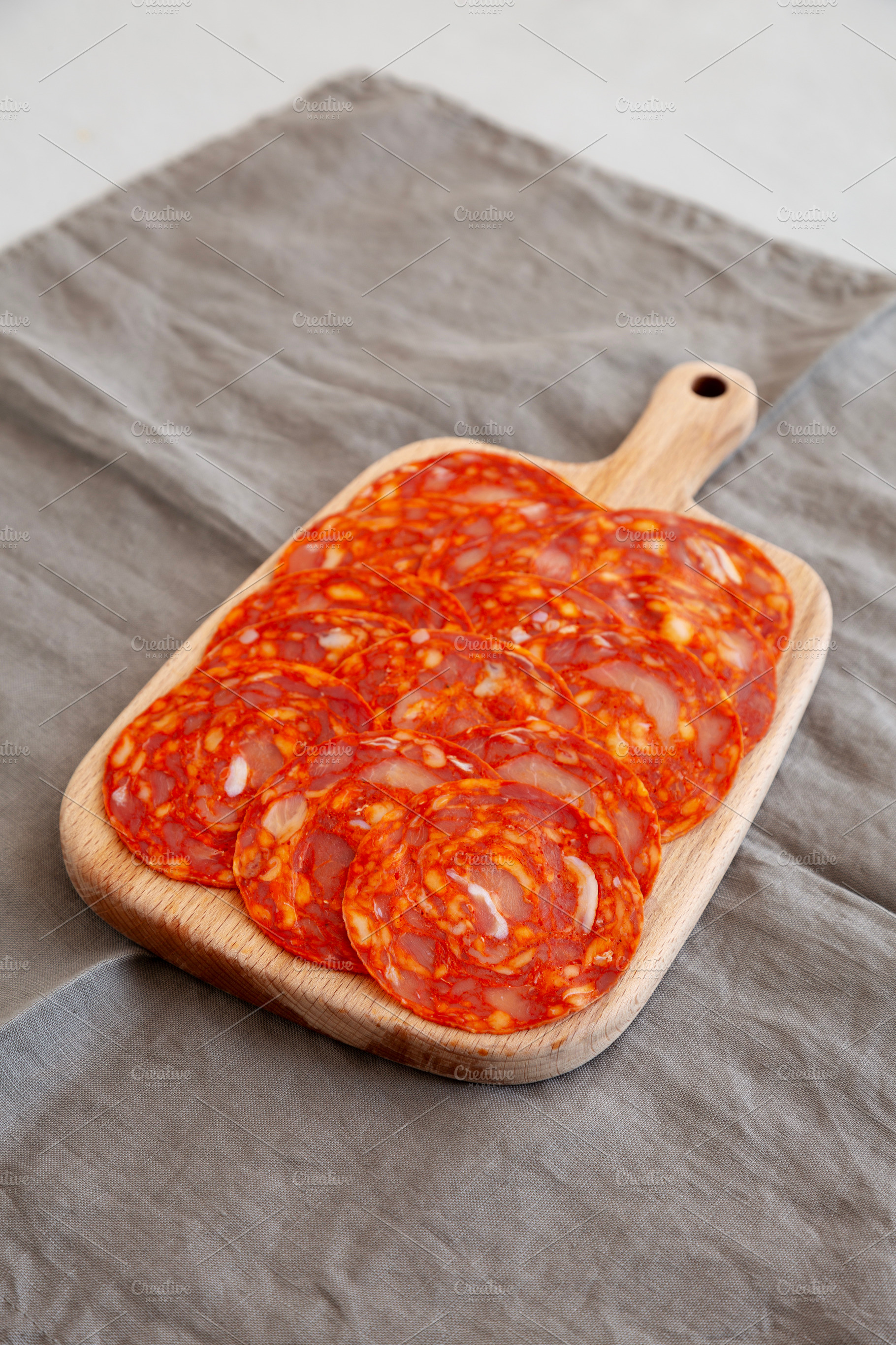 Cold Meat Chorizo Slices on a Wooden Board, side view., a Food & Drink Photo by LiudmylaChuhunova