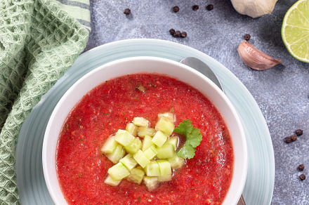 Cold soup Gazpacho garnished with cucumber and cilantro, in bowl, vertical top, a Food & Drink Photo by iuliia_n