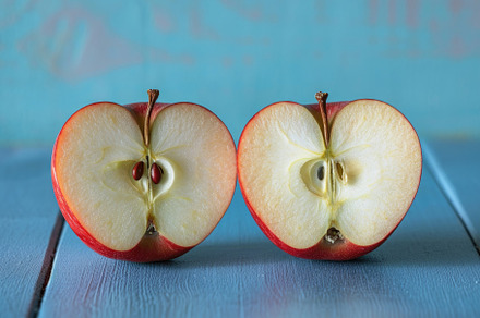 A ripe red apple is cut in half and, a Photo by Iftikhar Alam