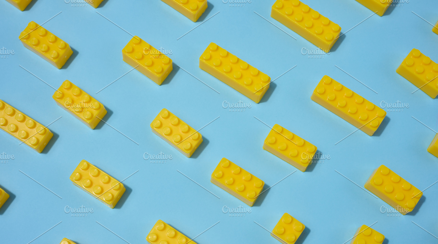 Scattered yellow plastic toy building bricks on a blue backgroun, a School & Education Photo by ndanko