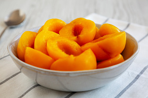 Healthy Organic Canned Peach Halves in a Bowl, side view., a Food & Drink Photo by LiudmylaChuhunova
