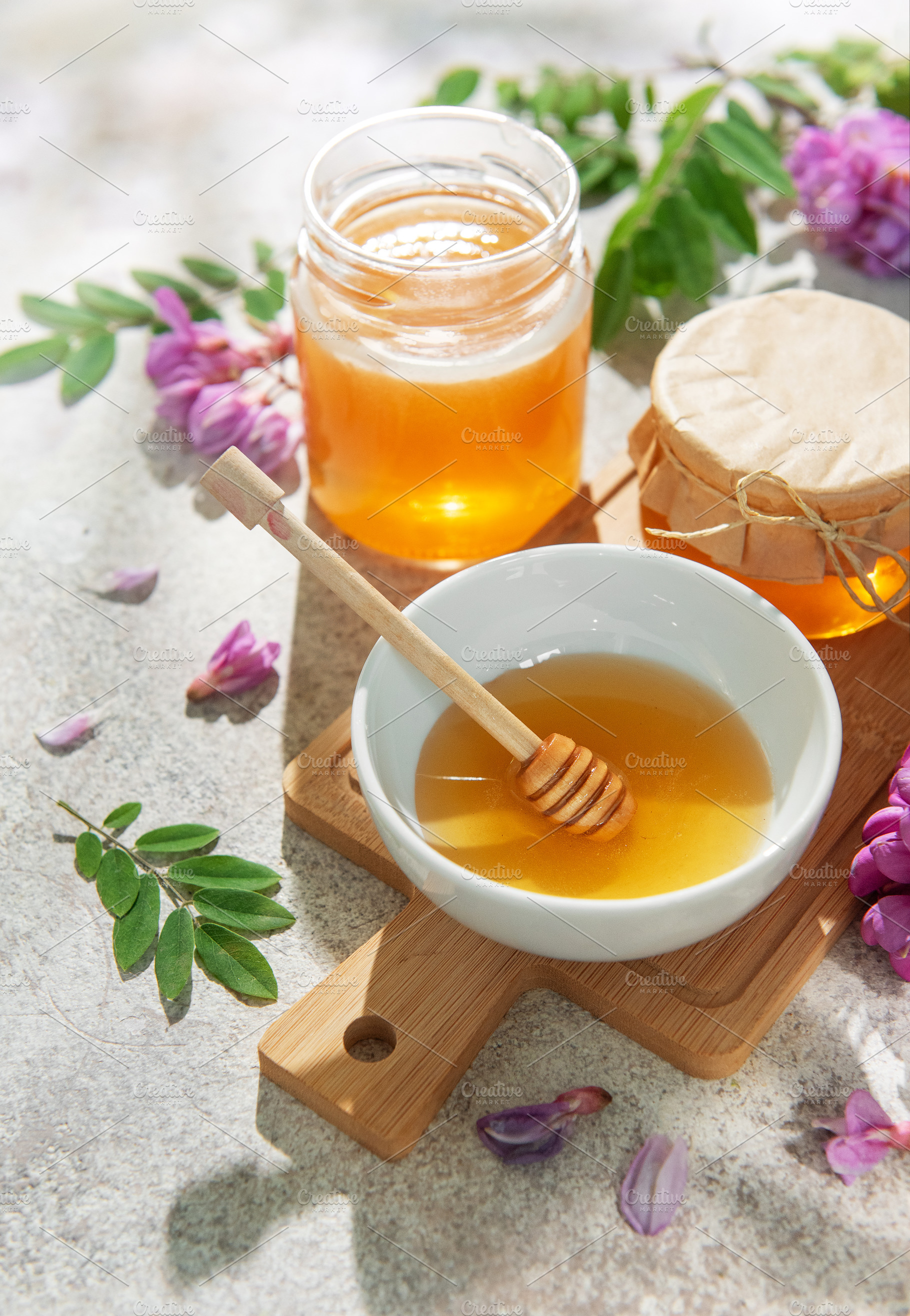 Natural honey in bowls and jars with robinia flowers, a Food & Drink Photo by Olena Rudo