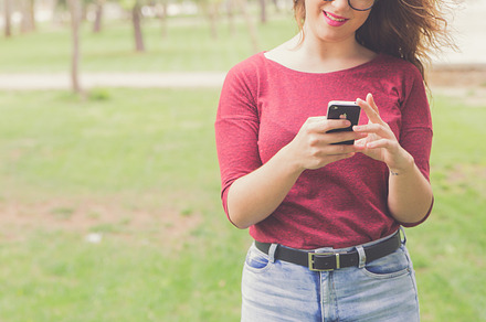 At the park featuring beautiful woman, glasses, and holding phone