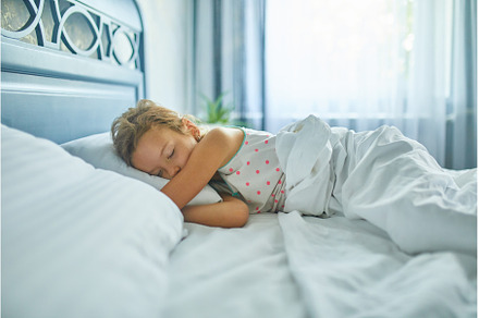 Little girl sleeping on a big and, a Person Photo by IlliaBondarPhotography