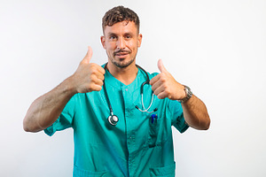 Smiling Doctor Giving Two Thumbs Up, a Person Photo by karrastock