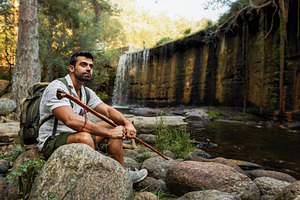 Hiker resting by a river and waterfa, a Sports & Recreation Photo by Perpis