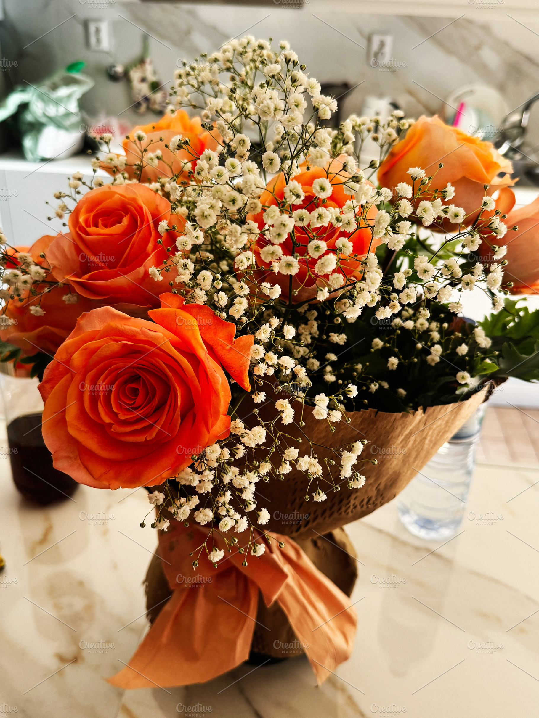 Vibrant orange rose bouquet with baby breath arrangement in elegant wrapping, a Photo by AS photostudio