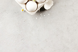 White Eggs in Carton with Chamomile Flowers on Light Background, a Holiday Photo by Natalia Klenova's Shop