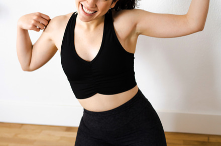 Funny young woman laughing at herself flexing arms after her tra, a Sports & Recreation Photo by asife