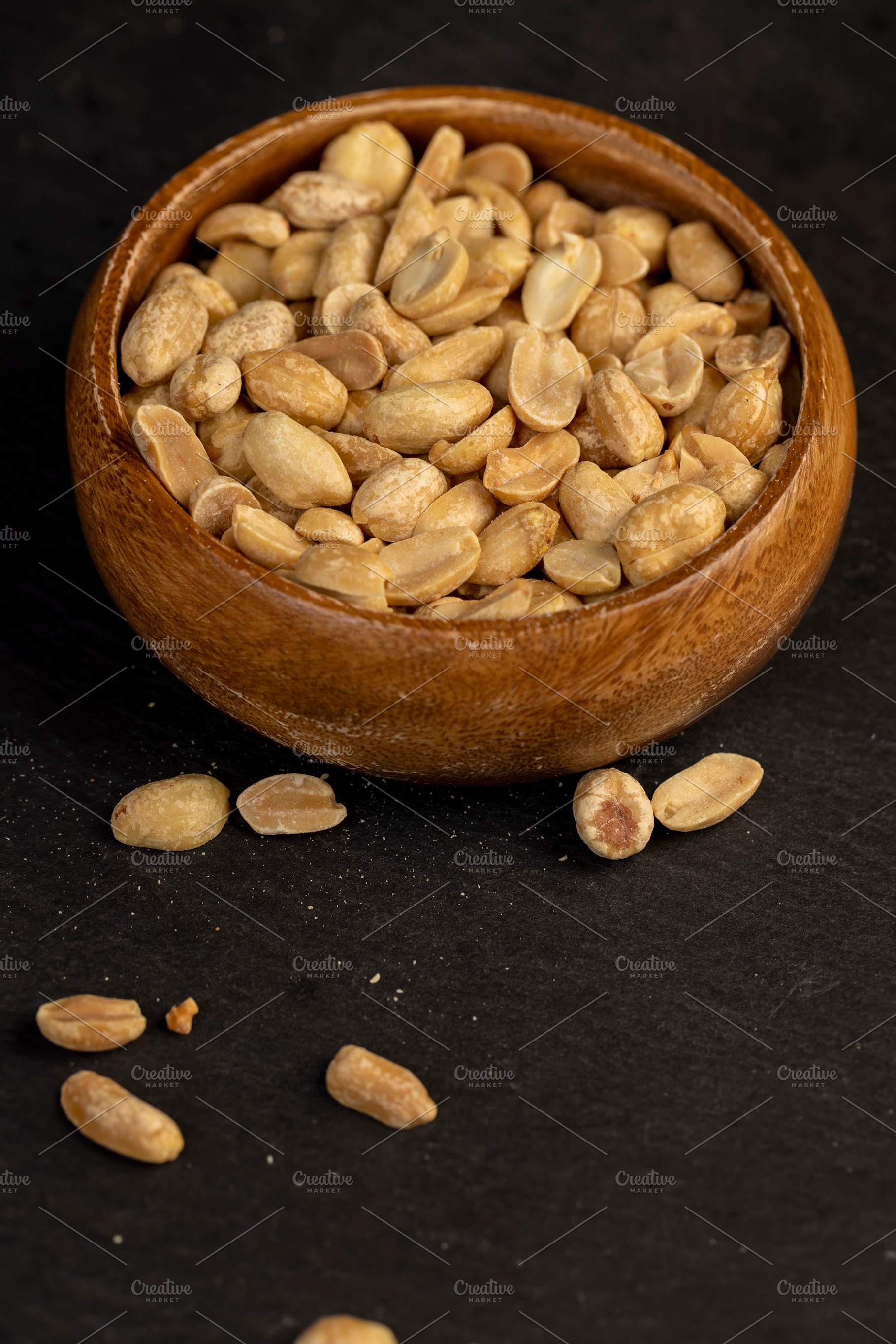 peanut kernels in a wooden bowl, fried yellow peanuts with a little salt on the, a Photo by rsoollAI