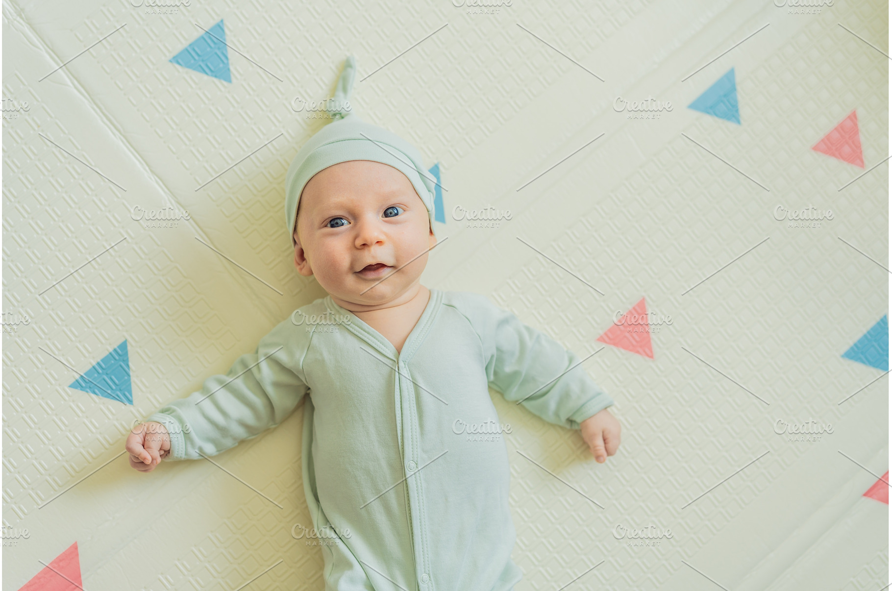 Adorable baby in a green hat lying, a Person Photo by Elizaveta Galitskaya