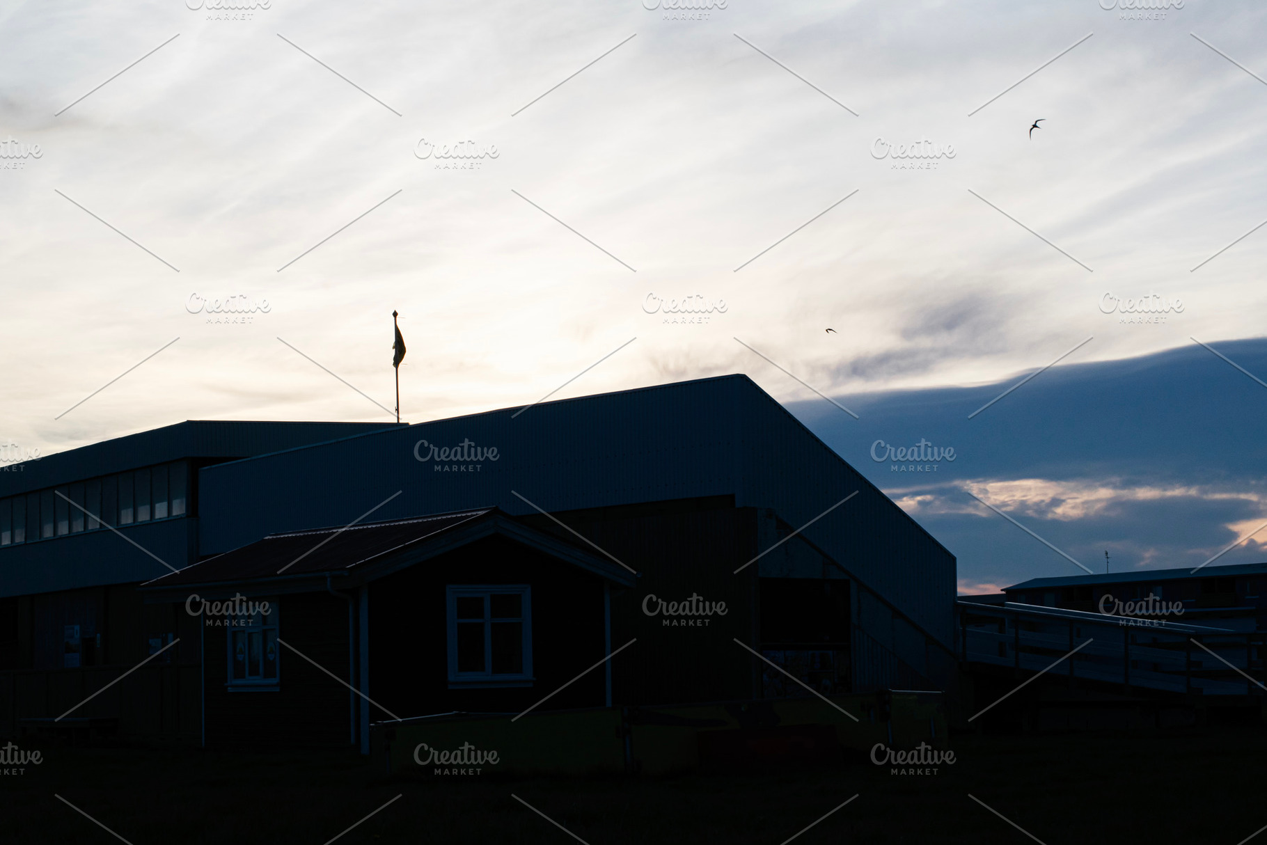 Silhouetted buildings and sky during sunset in Akranes, Iceland, a Photo by AS photostudio