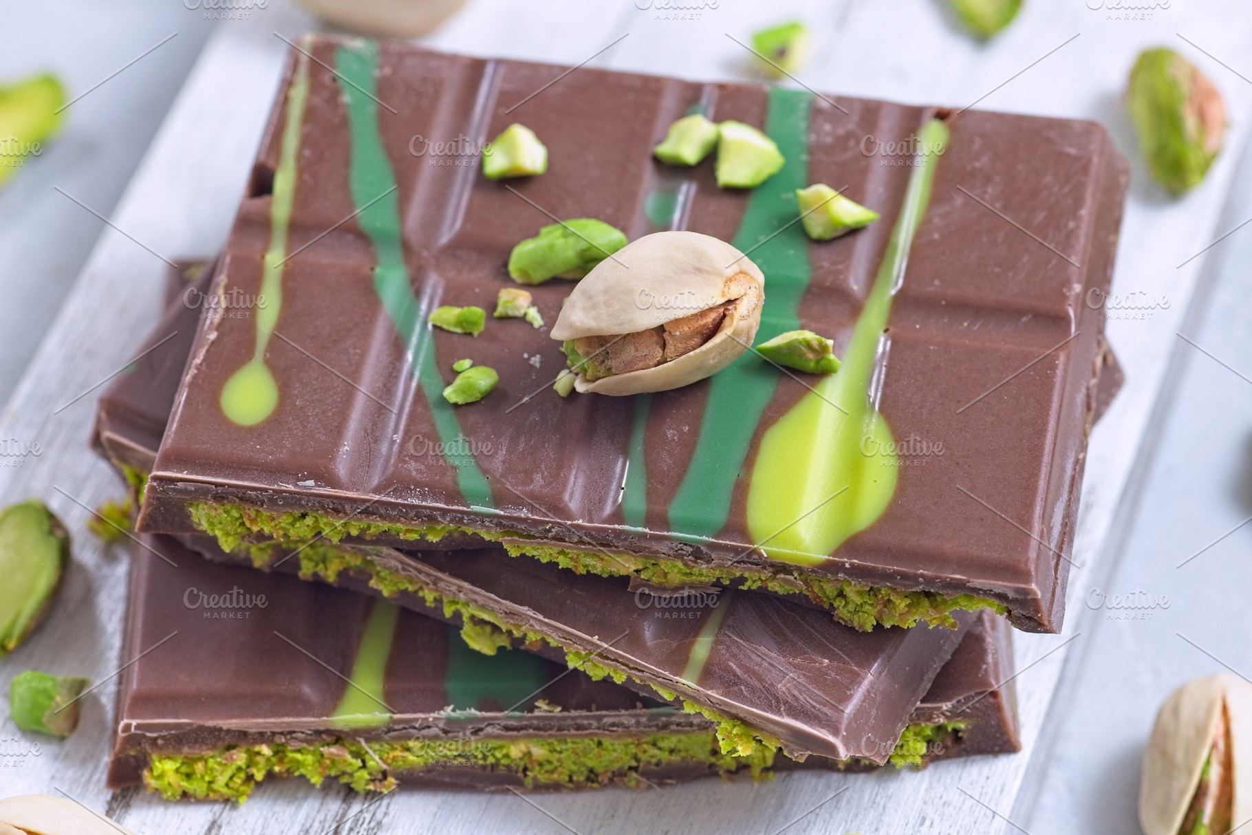 Dubai style milk chocolate bar with pistachio and kadaifi filing, lying on cutt, a Food & Drink Photo by iuliia_n