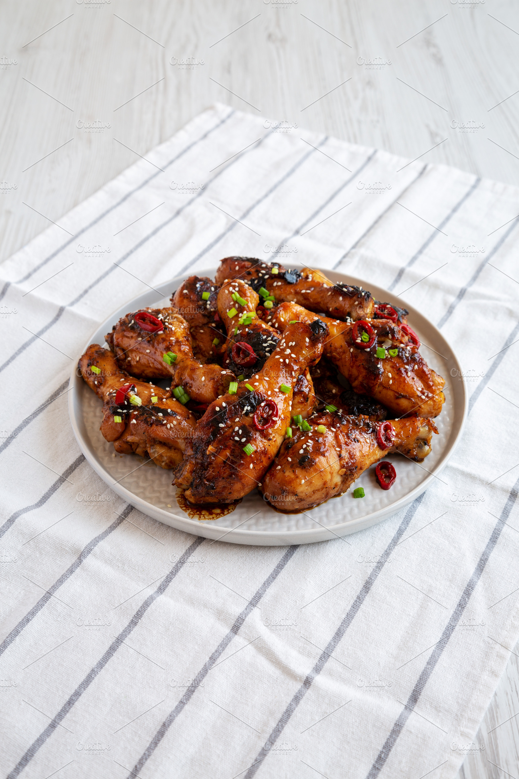 Homemade Easy Sticky Chicken Drumsticks on a Plate, side view., a Food & Drink Photo by LiudmylaChuhunova