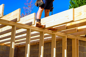 Construction worker stands on wooden