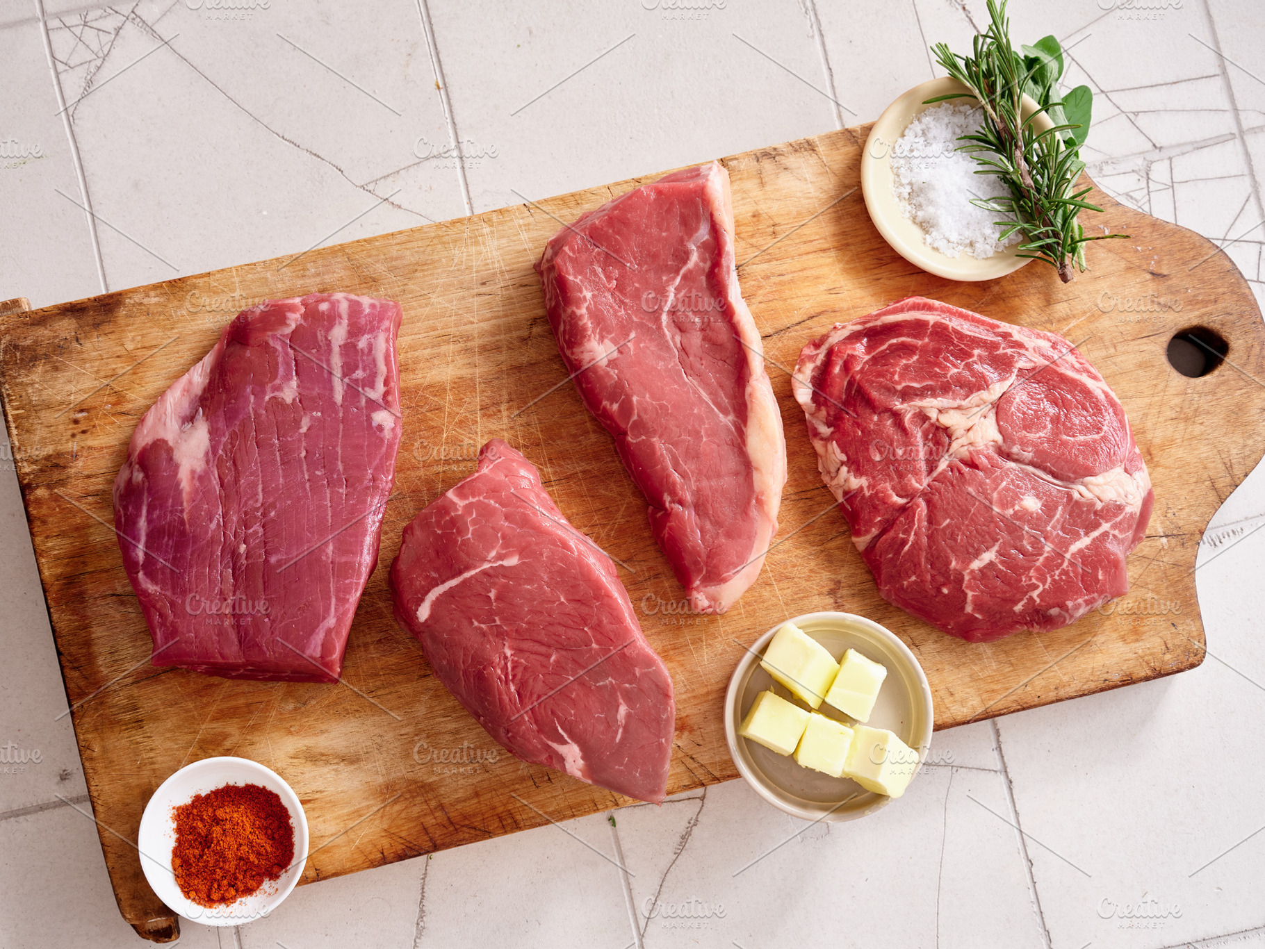 Raw rib-eye, roast beef, flank and rump steak on wooden cutting board with herb, a Food & Drink Photo by Asya Nurullina