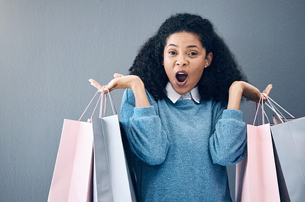 Wow, discount and portrait of woman with shopping bags, retail therapy and surprise at sale on wall. Deal, excited and happy girl holding products from a shop, market or mall on a background, a Photo by Peopleimages.com