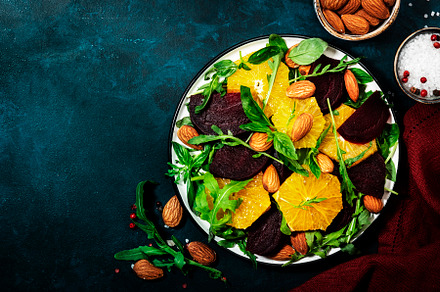 Beet Salad with orange, arugula and almonds on blue table backgr, a Food & Drink Photo by 5PH
