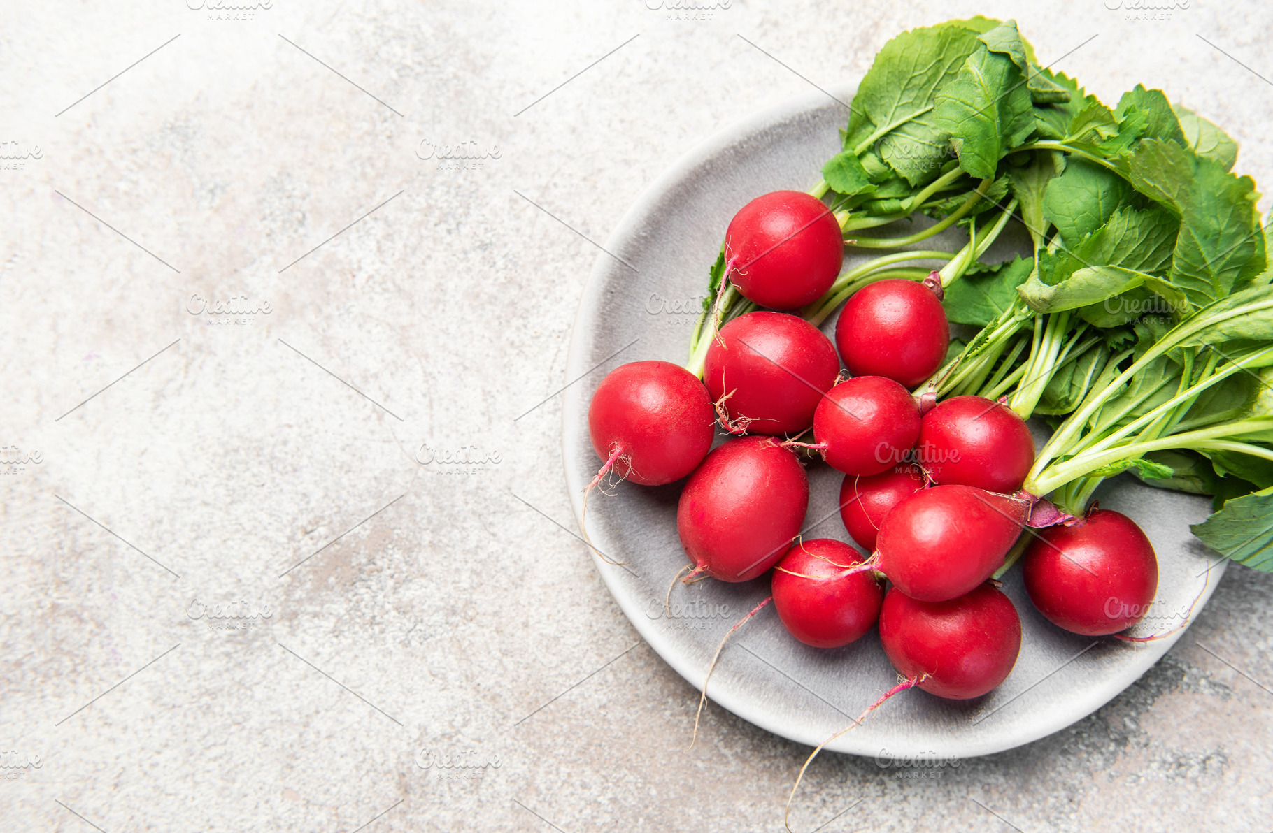 Fresh spring radishes with green leaves on plate, a Food & Drink Photo by Olena Rudo