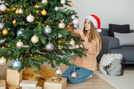 Teenage girl decorates the Christmas tree, a Holiday Photo by Olena Rudo