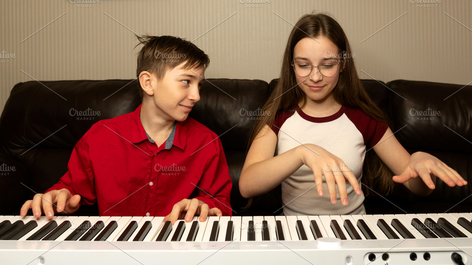 Boy and girl playing the piano, a School & Education Photo by Elena Vagengeim