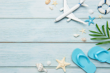 Planning summer vacation with airplane, flip flops and seashells