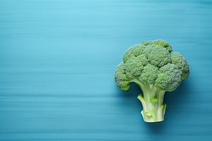 Green ripe broccoli on blue background, a Food & Drink Photo by AlyaAnd