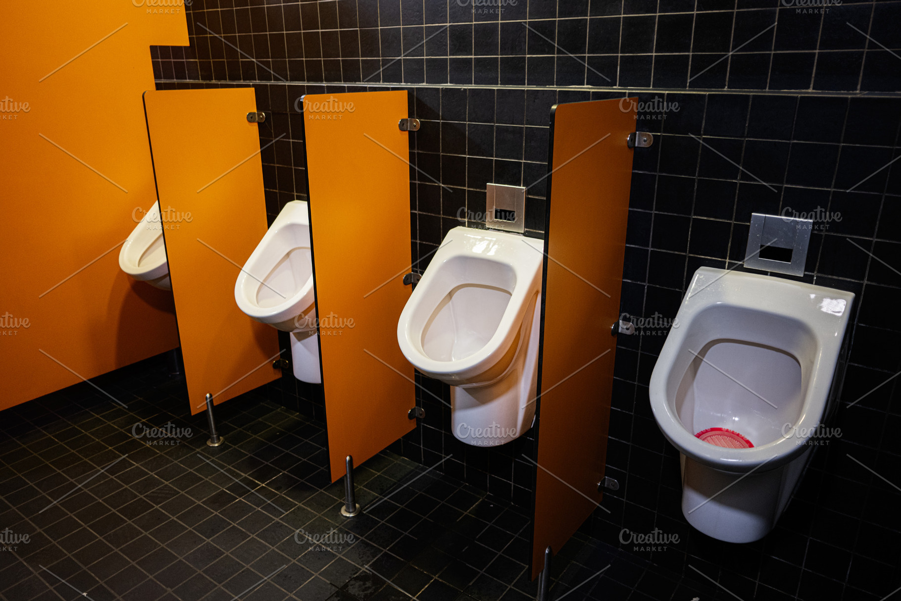 Modern public restroom with orange walls and white ceramic urinals separated by, a Photo by AS photostudio