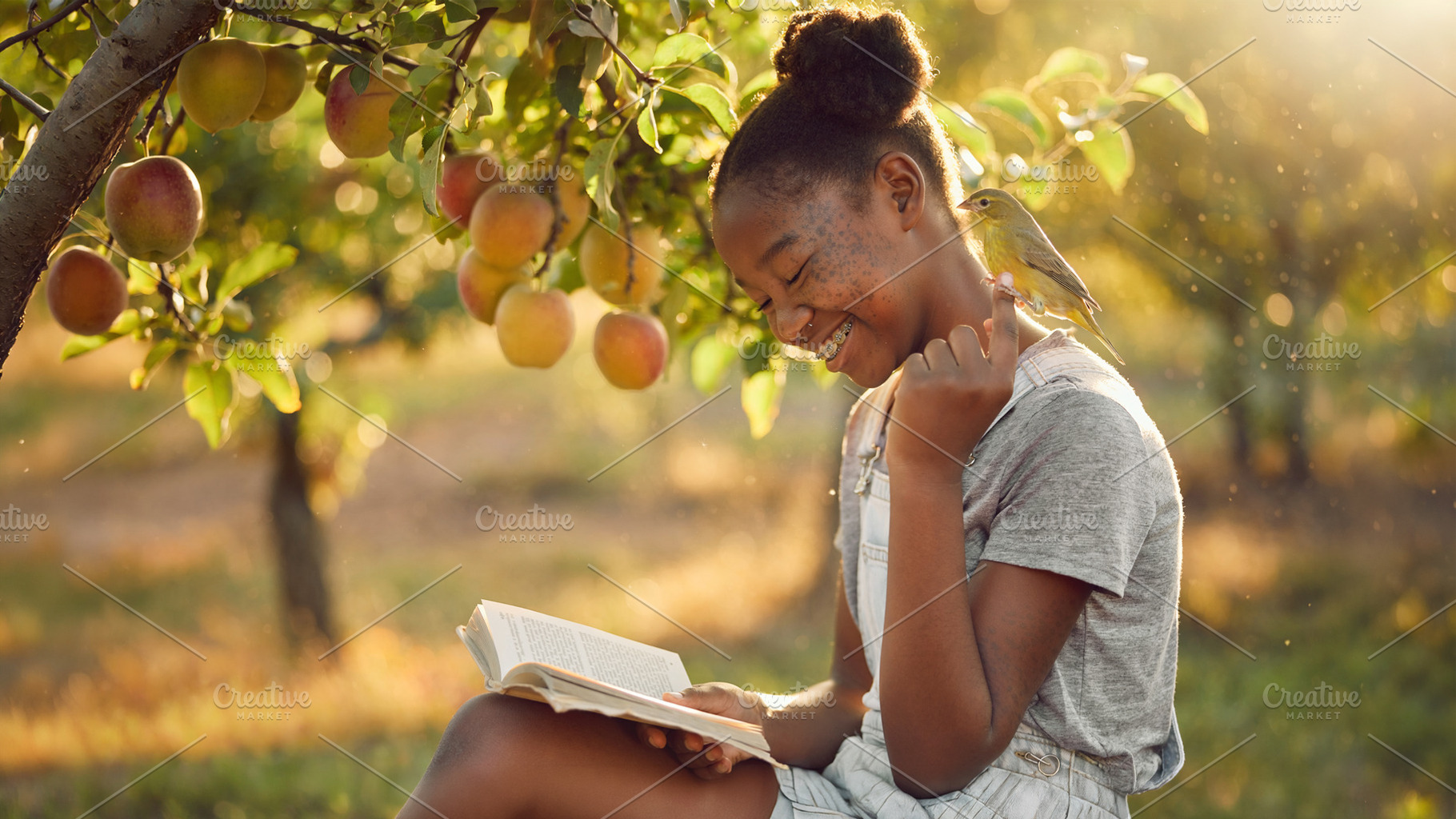 Young girl reading a book under an apple tree, a Person Photo by DanFLCreativo