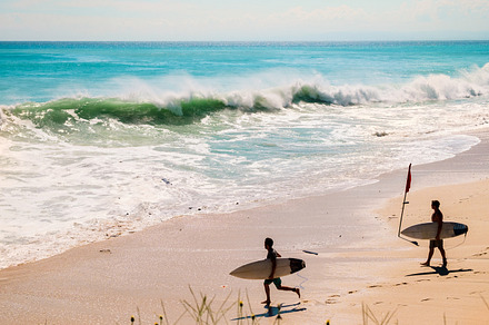 Silhouettes of surfers on the ocean beach, Bali island, Indonesia. People walking with a surf in hands across the sea shore with huge waves at sunny sumer day, a Sports & Recreation Photo by ifnotelse