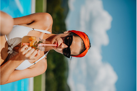 Young woman sitting by swimming pool