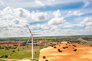 Wind turbines spanning across vast rural landscape under bright sky