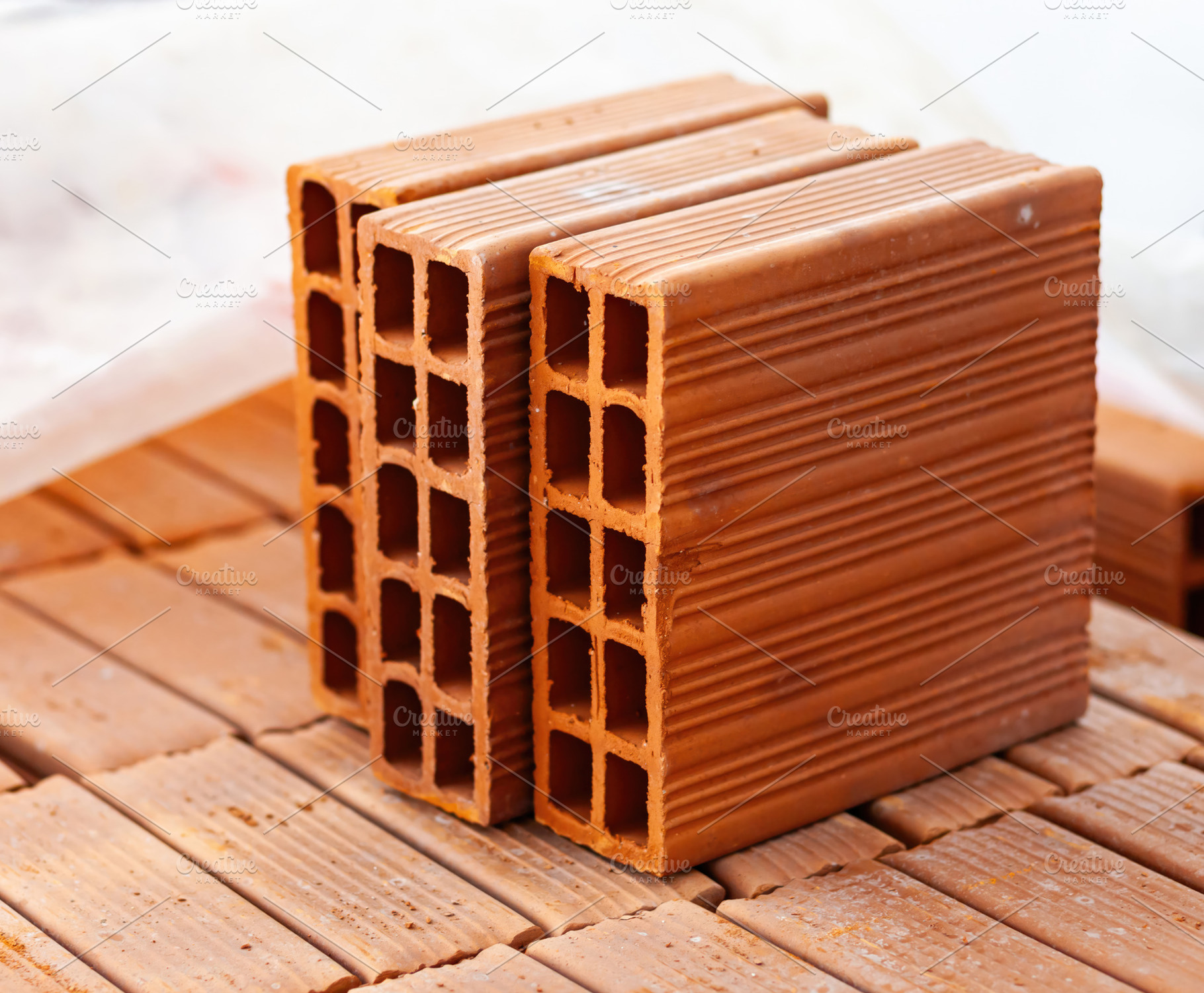 Close up of hollow bricks resting on wooden pallet during building construction, an Industrial Photo by Antonio Gravante Market