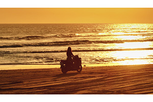 Woman riding scooter on Bali beach, a Person Photo by Goinyk
