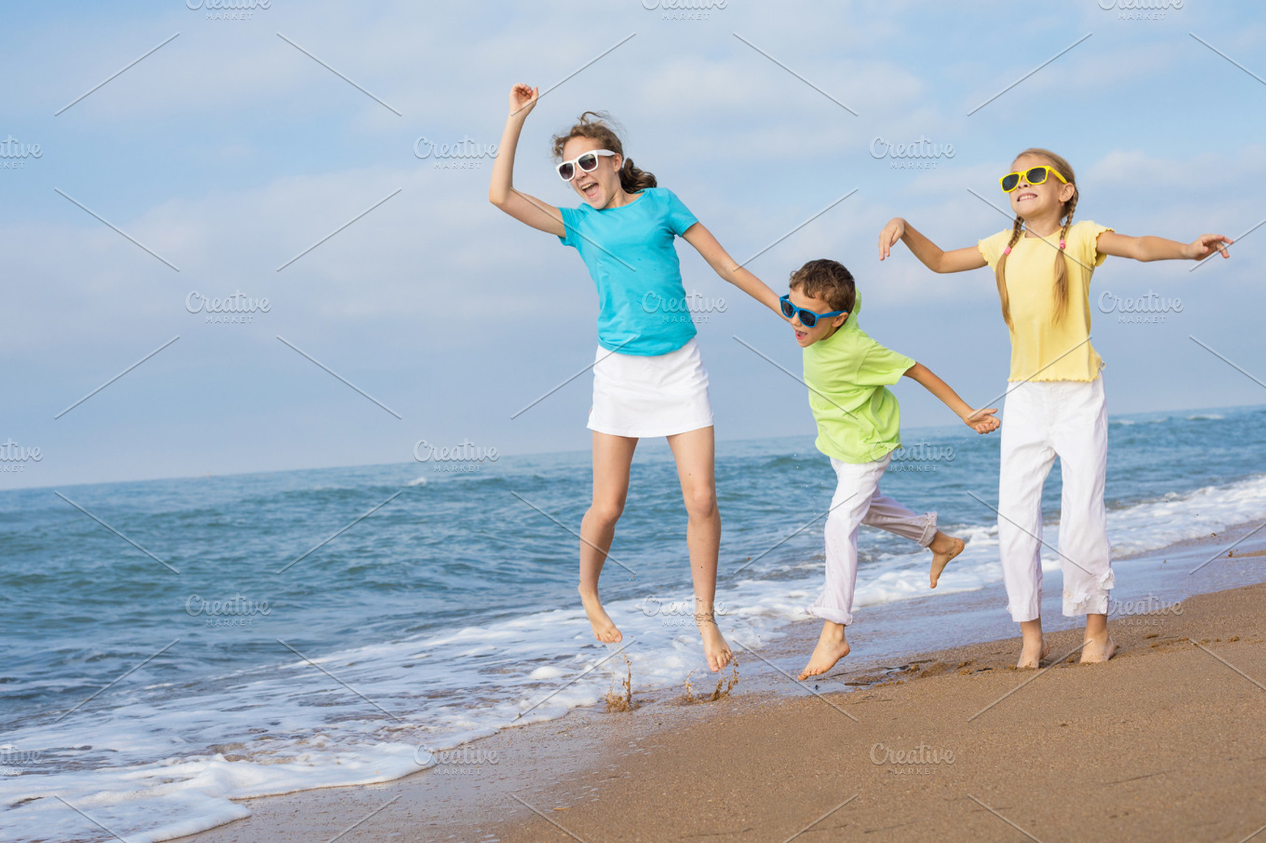 Happy children running on the beach featuring friendship, happy, and smile, a Person Photo by altanaka